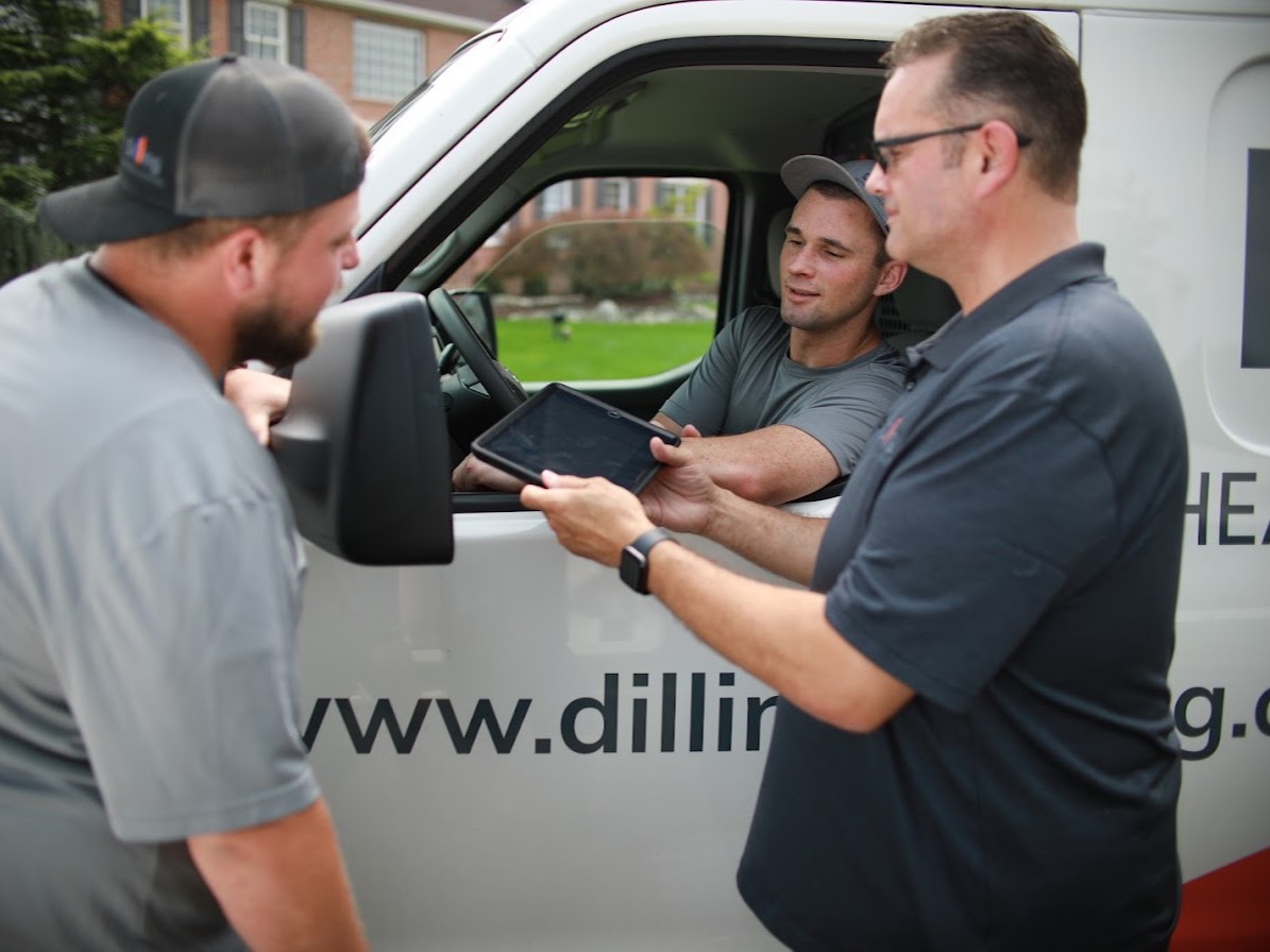 Dilling team reviewing job details on a tablet beside a service van