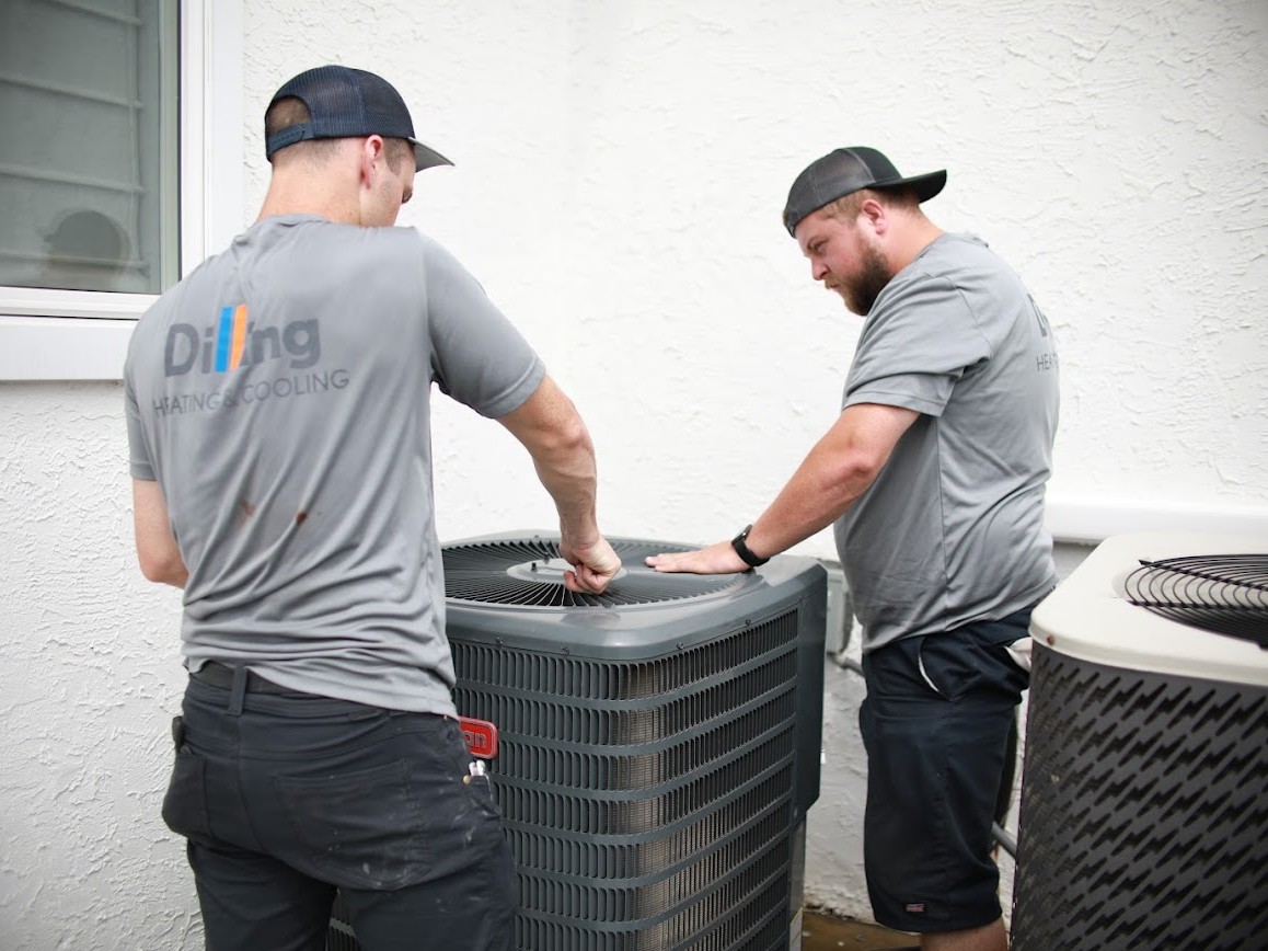 Two Dilling technicians working on an outdoor condenser unit