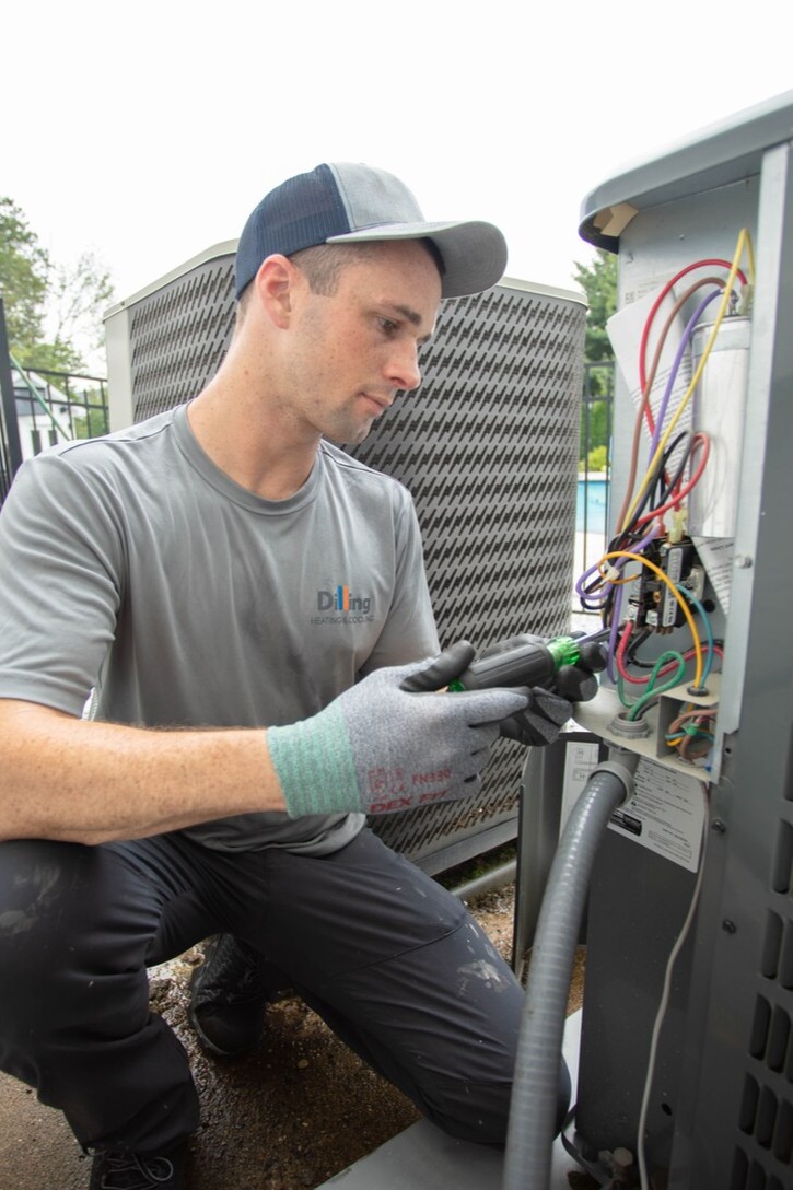 Two Dilling technicians servicing an outdoor air conditioning unit